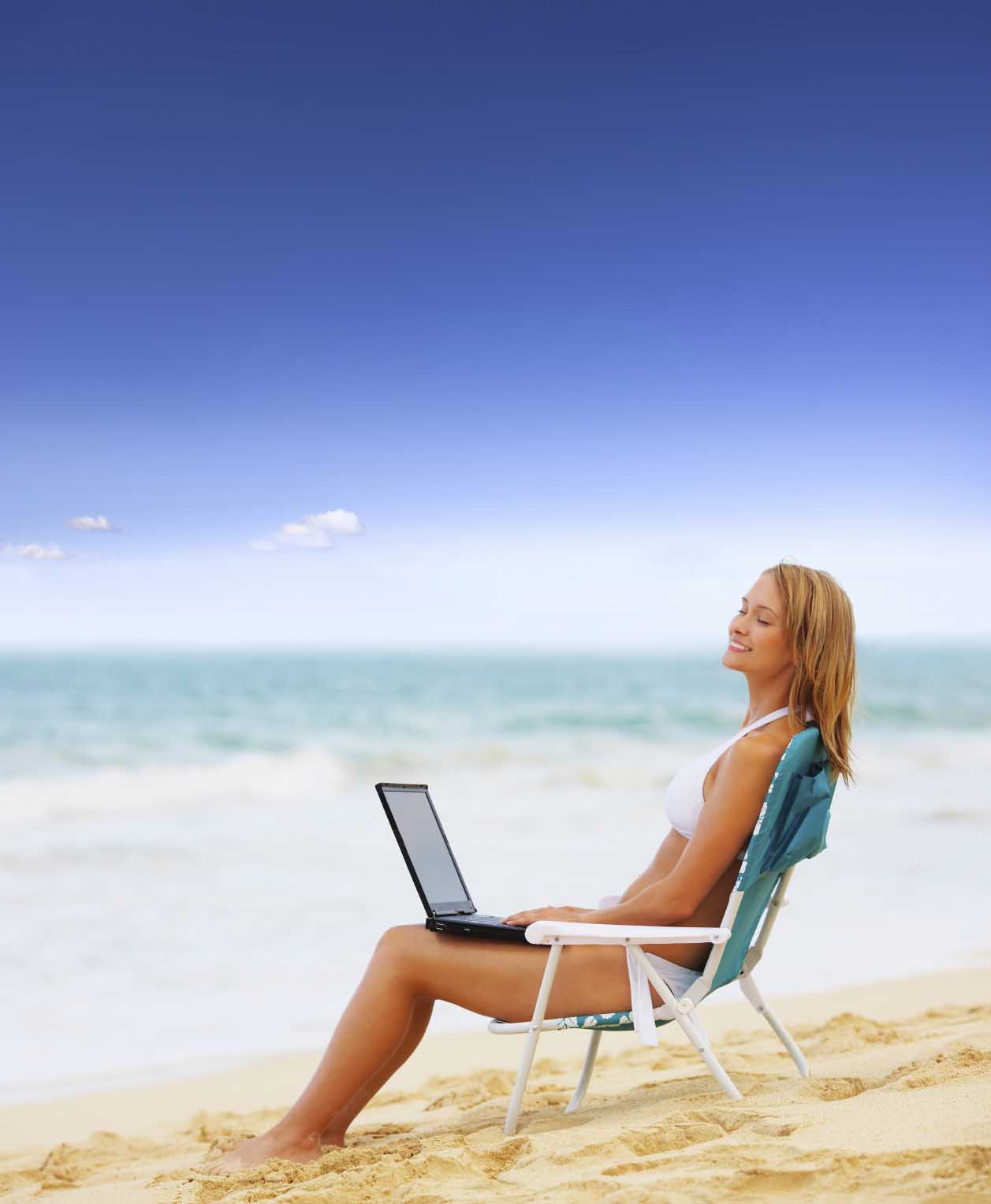 Девушка с ноутбуком на берегу моря